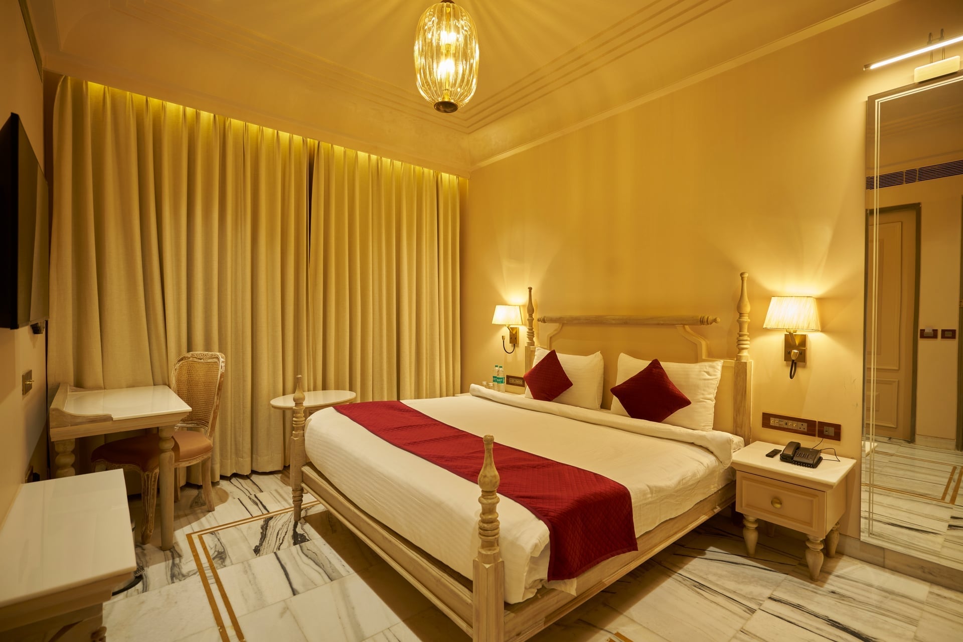 Heritage Deluxe room at Ananth Aravali Resort featuring traditional Rajasthani decor, king bed, and mountain views